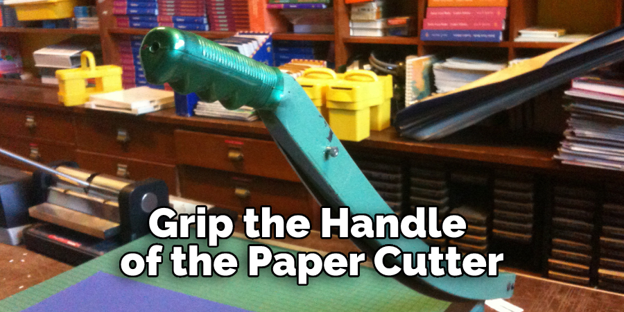 Grip the Handle of the Paper Cutter